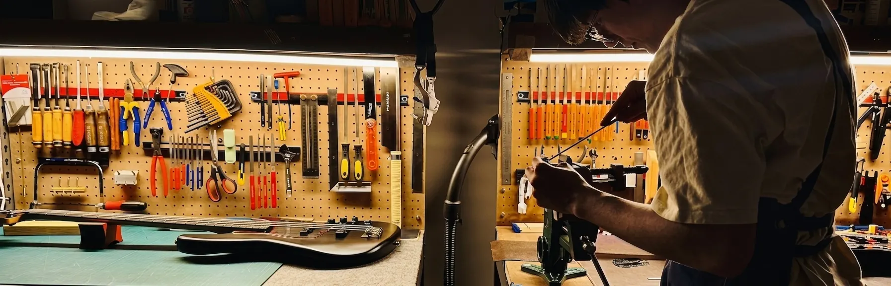 Inside the workshop — guitars waiting on the bench, tools on the wall